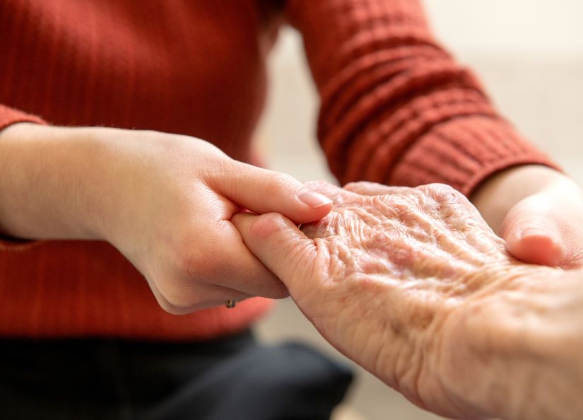 An older person's hand is being massaged by a physiotherapist.